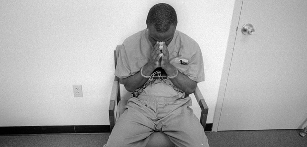 Ian Manuel is sitting and praying during one of his days in prison.